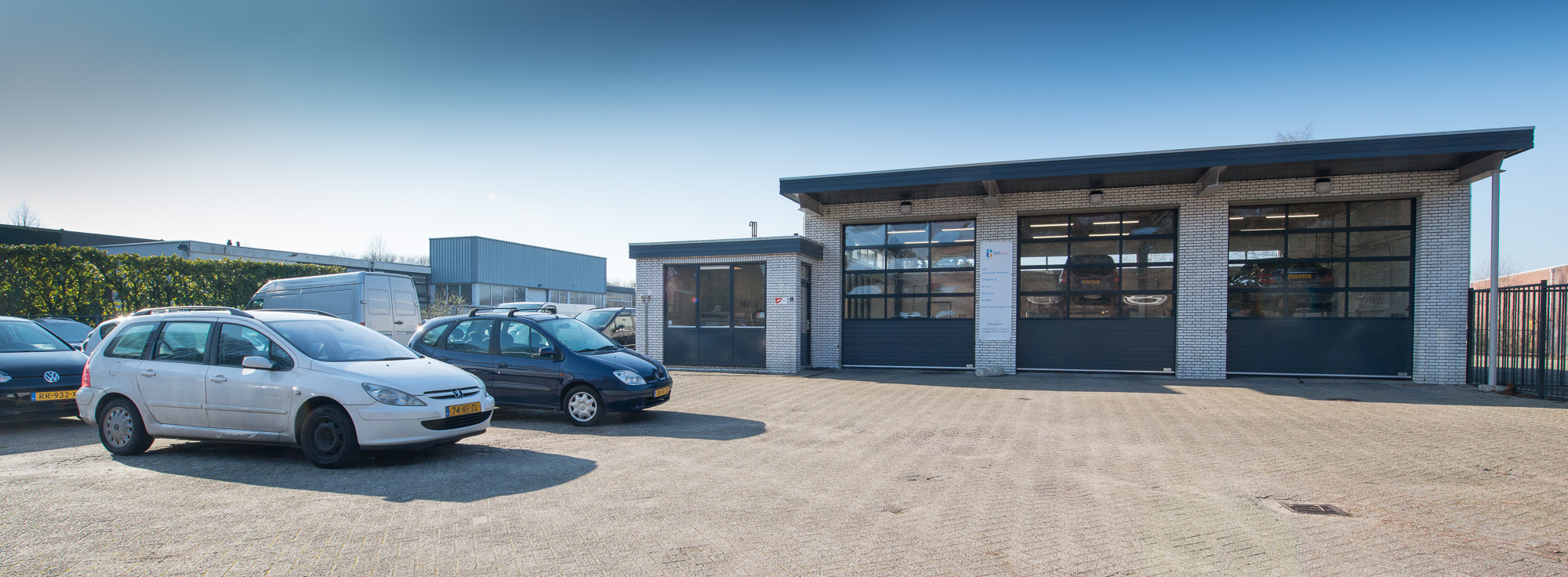 Beil Auto aan de Hoolstraat 5 in Weert: drie werkplaatsdeuren en het terrein ervoor